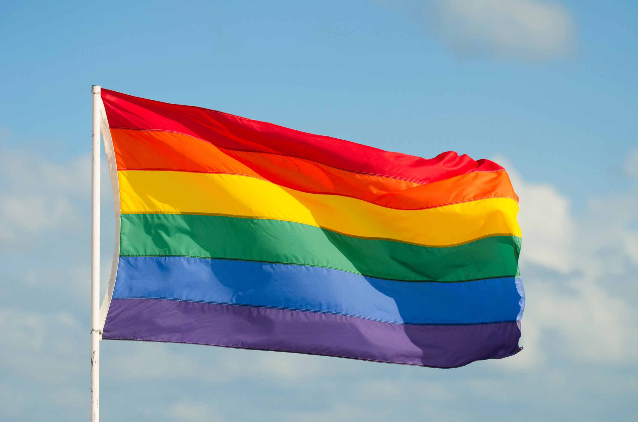 Gay Pride Rainbow Flag Flying in the Wind on Flag Pole