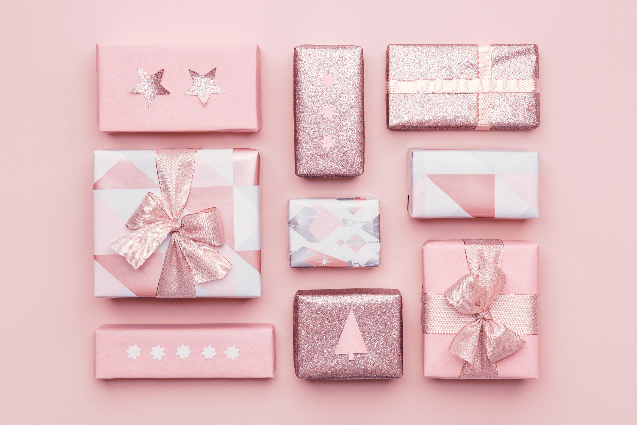 Gift wrapping composition. Beautiful nordic christmas gifts isolated on pastel pink background. Pink colored wrapped xmas boxes.