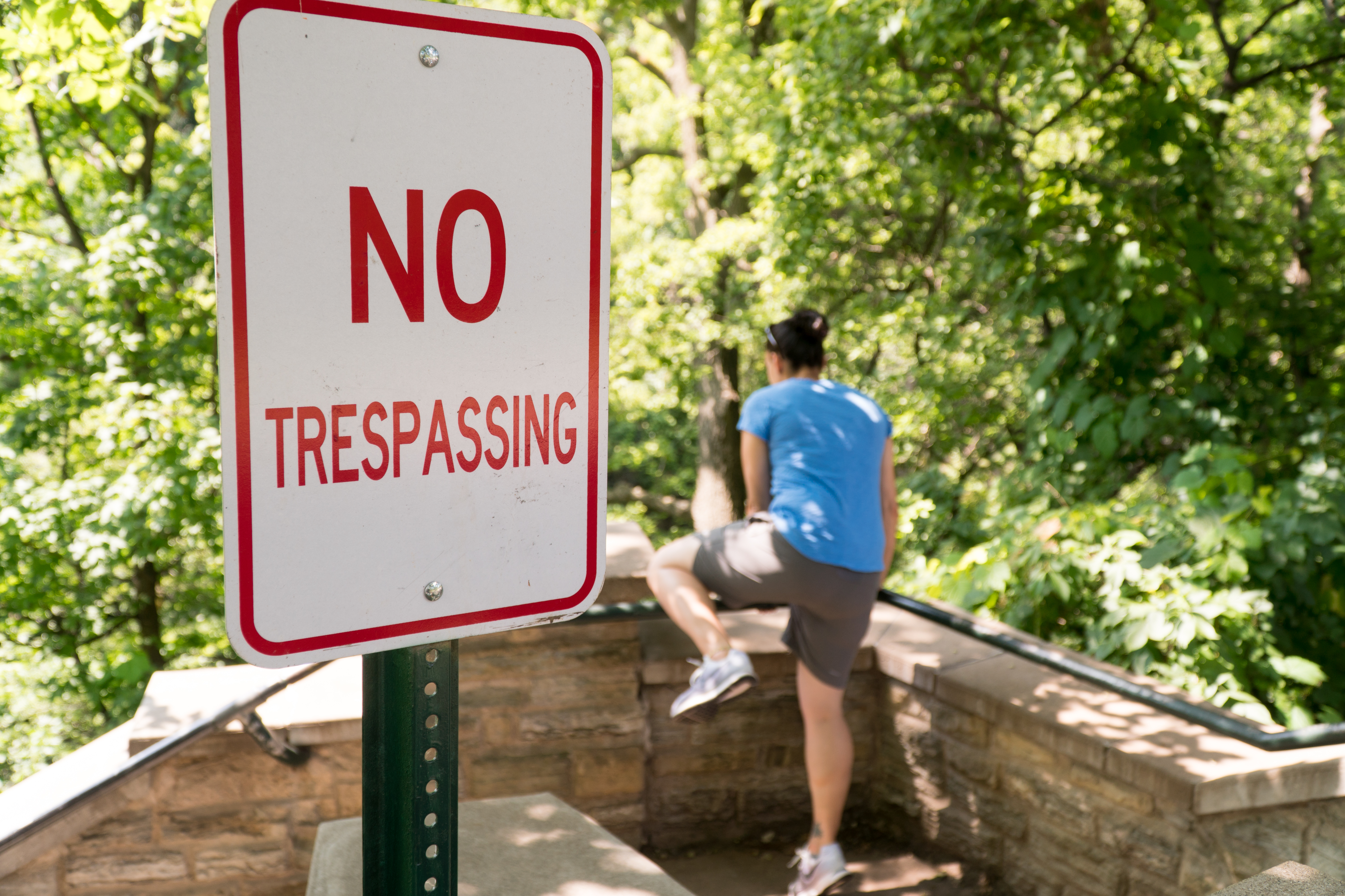 Young,Woman,Attempt,To,Jump,Over,Railing,Into,Restricted,Area