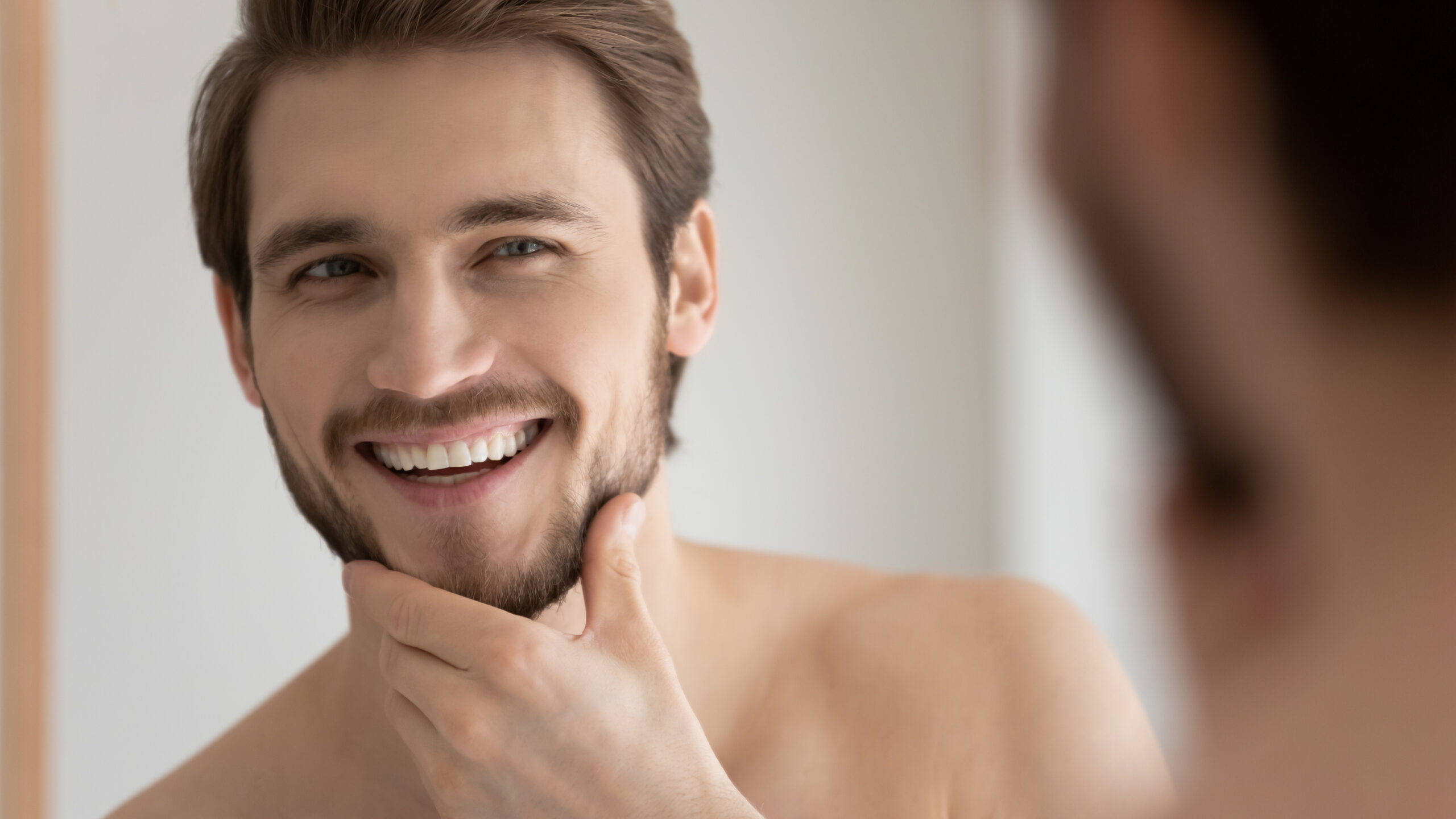 Man touch bristled chin feels satisfied after facial shaving