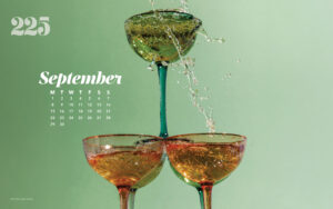 Desktop wallpaper with three stacked wine glasses and green background